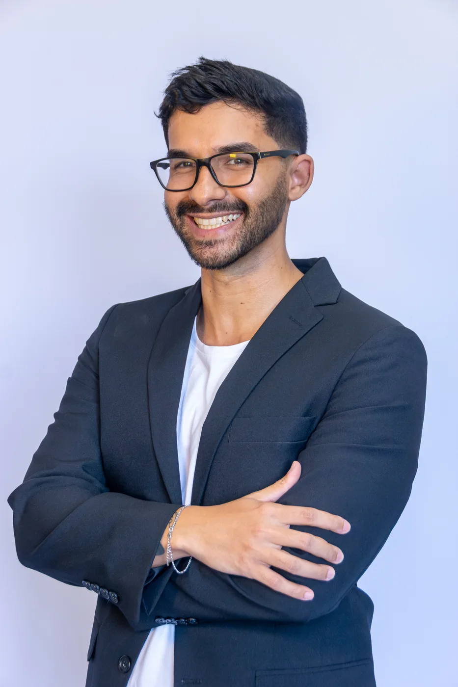 Formando de braços cruzados, retrato executivo em estúdio com fundo branco